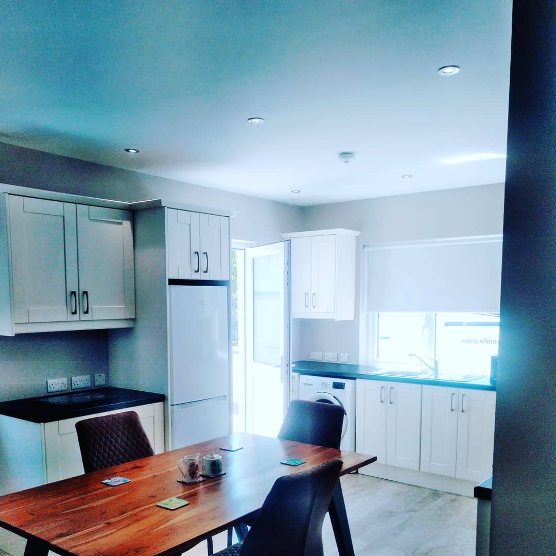 A kitchen and dining area with recessed ceiling lights